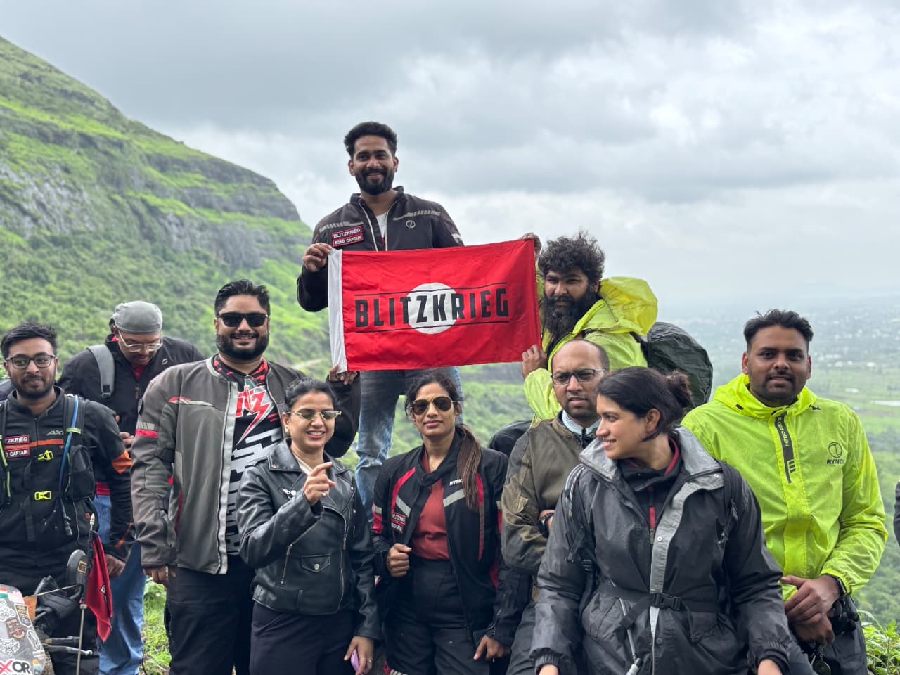 BRC riders holding the club flag on a monsoon ride in the Sahyadris